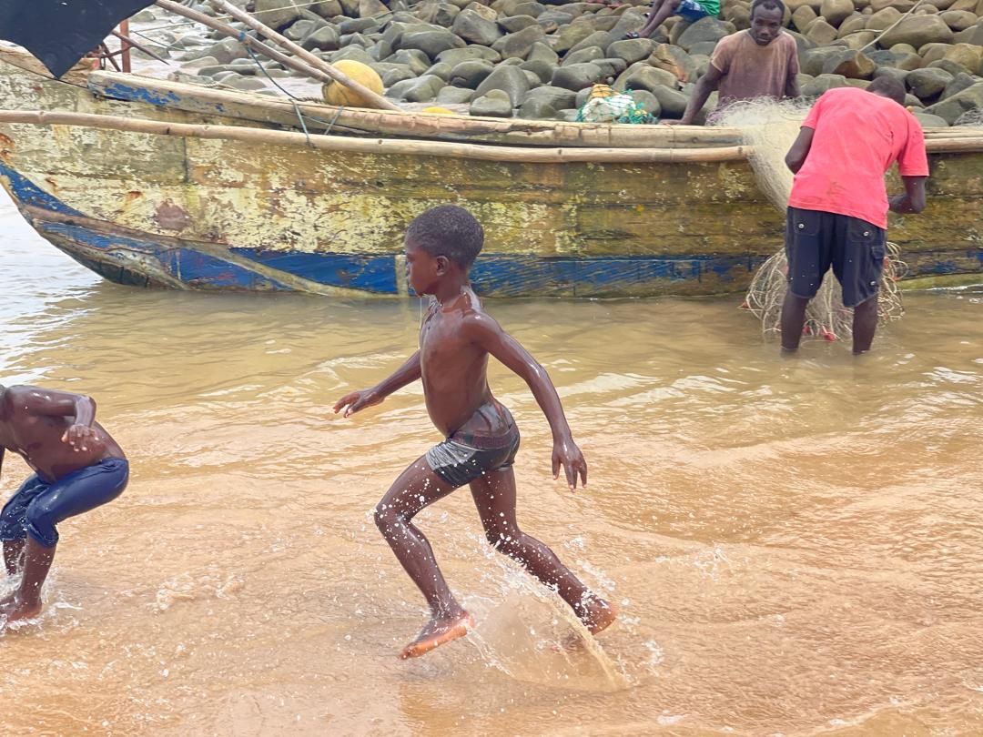 Children playing in the shallows near the fishing boats in Dixcove